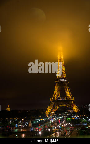 Der Eiffelturm bei Nacht mit seinen Gipfel im Nebel/Nebel/Wolken Stockfoto