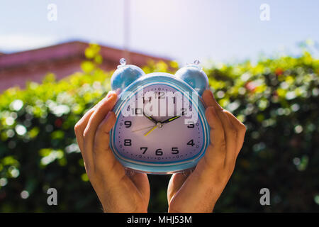 Zwei Hände, die Uhr vor Blätter Stockfoto