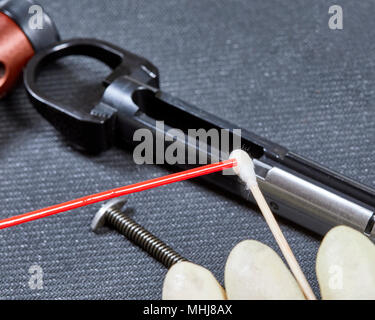 Die Schmierung der Waffe Öl auf ein Wattestäbchen in Vorbereitung gun Teile zu schmieren Stockfoto