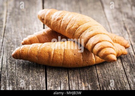Salzig Brötchen. Vollkorn Croissants auf alten Holztisch. Stockfoto