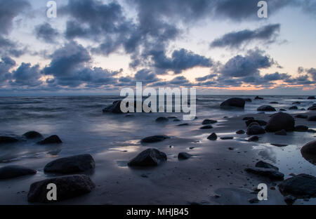 Eine Marine in der Dämmerung mit großen dunklen Steine auf einen leeren Strand in der Nähe von Kaltene, Lettland. Stockfoto