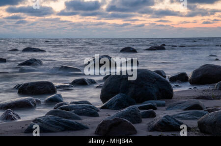 Eine Marine in der Dämmerung mit großen dunklen Steine auf einen leeren Strand in der Nähe von Kaltene, Lettland. Stockfoto