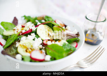 Gemischter Salat mit Baby aus der roten Salat, tatsoi, Rucola, Roter Mangold, Radieschen, Gurken und Fetakäse mit Olivenöl und Balsamico Dressing Stockfoto