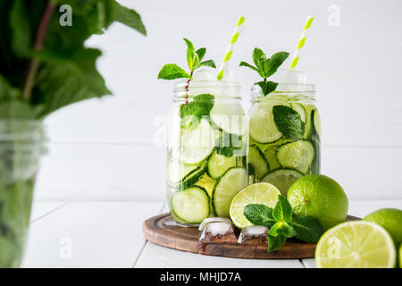 Obst und Kräuter infundiert Wasser mit Gurke, Limette und Minze auf weißem Hintergrund. Das Konzept der Entschlackung und Gewichtsabnahme. Stockfoto