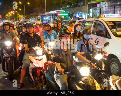 Straße mit Motorrädern und Taxis nachts im District 1 Ho Chi Minh City, Vietnam überlastet. Stockfoto
