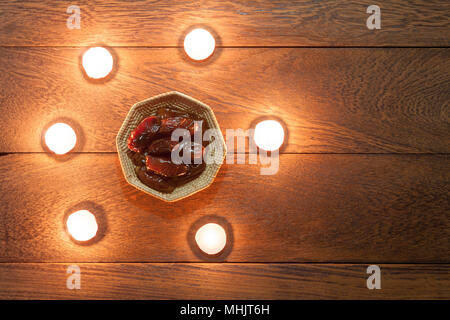 Tabelle Ansicht von oben Luftbild der Dekoration Ramadan Kareem urlaub Hintergrund. Flach Termine in Holz Korb mit weißen Aromatherapie Kerze. Essent Stockfoto