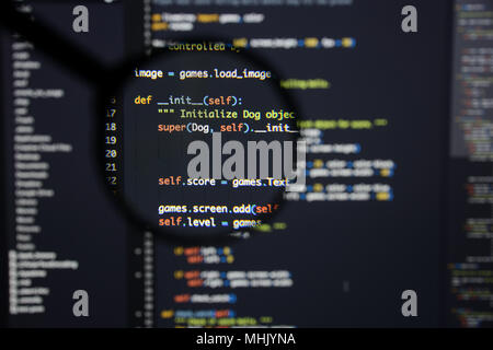 Real Python Code entwickeln. Programmierung Workflow abstrakter Algorithmus Konzept. Linien von Python Code sichtbar unter der Lupe. Stockfoto
