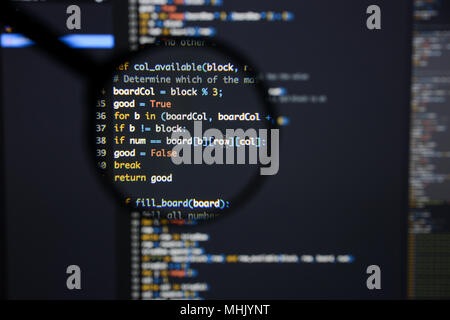 Real Python Code entwickeln. Programmierung Workflow abstrakter Algorithmus Konzept. Linien von Python Code sichtbar unter der Lupe. Stockfoto