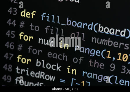 Real Python Code entwickeln. Programmierung Workflow abstrakter Algorithmus Konzept. Linien von Python Code sichtbar unter der Lupe. Stockfoto