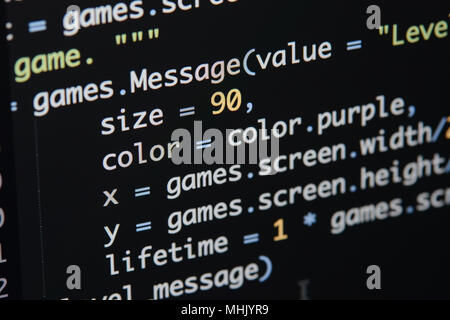 Real Python Code entwickeln. Programmierung Workflow abstrakter Algorithmus Konzept. Linien von Python Code sichtbar unter der Lupe. Stockfoto