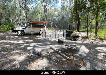Eine schattige Bushcamp mit einem Nissan Patrol 4x4 Auto, Markise, Swag und Feuer ring, Davies Creek National Park in der Nähe von Mareeba, Far North Queensland, FNQ, QLD, Au Stockfoto