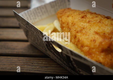 Traditionelle gebratener Kabeljau und Chips in einer Box mitgenommen auf einen hölzernen Tisch. Querformat. Stockfoto