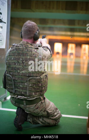 Ein Mitglied des britischen Joint European Training Team schießt mit einem M9 Pistole in die kniende Position während einer multinationalen Schulungsveranstaltung auf chièvres Air Base, Belgien, 16. März 2018. (U.S. Armee Stockfoto