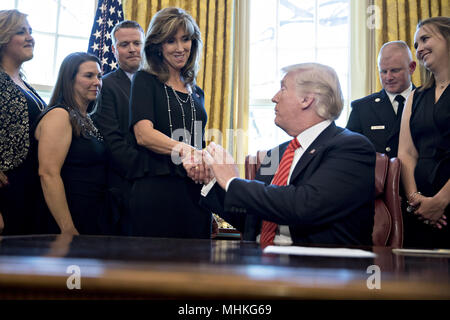 Präsidenten der Vereinigten Staaten Donald Trump, rechts, schüttelt Hände mit Tammie Jo Shults, Southwest Airlines Co. Kapitän, beim Treffen mit der Besatzung und der Passagiere von Southwest Airlines Flug 1380 im Oval Office des Weißen Hauses in Washington, DC, USA, am Dienstag, den 1. Mai 2018. Ein Motor auf dem Flug 1380 von Südwesten, einer Boeing Co.737-700 für Dallas aus New York's LaGuardia Airport gebunden, explodierte und eine Notlandung am 17. April senden Splitter in die Ebene und das Töten eines Pkw in der Nähe von einem Fenster sitzen. Credit: Andreas Harrer/Pool über CNP | Verwendung weltweit Stockfoto