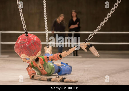 London, Großbritannien. 2. Mai 2018. Jordan Wolfson farbigen Skulptur, eine groß angelegte animatronic Installation in den Tanks in der Tate Modern. Es verfügt über eine bedrohliche Marionette über 7 Meter hoch, die angehoben wird, gezogen, gezerrt und auf den Boden fiel durch mechanisierte Ketten an beiden Extremitäten angebracht. Die Abbildung bezieht sich auf verschiedene Darstellungen von Kindheit aus der amerikanischen Popkultur. Mit digitalen Bildern für Augen ausgestattet, Sensoren ermöglichen die Marionette den Betrachter mit ihren starren zu beheben, da es Mund eine kryptische Liste der bedrohlichen Aussagen. Credit: Guy Bell/Alamy leben Nachrichten Stockfoto