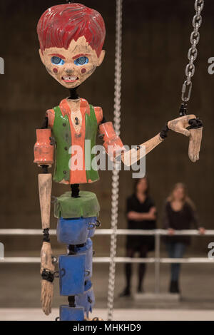 London, Großbritannien. 2. Mai 2018. Jordan Wolfson farbigen Skulptur, eine groß angelegte animatronic Installation in den Tanks in der Tate Modern. Es verfügt über eine bedrohliche Marionette über 7 Meter hoch, die angehoben wird, gezogen, gezerrt und auf den Boden fiel durch mechanisierte Ketten an beiden Extremitäten angebracht. Die Abbildung bezieht sich auf verschiedene Darstellungen von Kindheit aus der amerikanischen Popkultur. Mit digitalen Bildern für Augen ausgestattet, Sensoren ermöglichen die Marionette den Betrachter mit ihren starren zu beheben, da es Mund eine kryptische Liste der bedrohlichen Aussagen. Credit: Guy Bell/Alamy leben Nachrichten Stockfoto