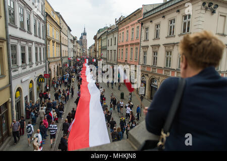 Krakau, Polen. Zum 2. Mai, 2018. Die Menschen halten eine polnische Flagge entlang der Royal Road während der nationalen Flagge Tag am Hauptplatz in Krakau. Stadt Pfadfinder, die heute versuchen, den nationalen Rekord entlang der Länge der nationalen Flagge zu brechen. Eine polnische Flagge mit 3 Meter Breite und mehr als zwei Kilometer lange Alle die königliche Straße besetzen, vom Florian Tor zu den Wawel-hügel. Credit: Omar Marques/SOPA Images/ZUMA Draht/Alamy leben Nachrichten Stockfoto