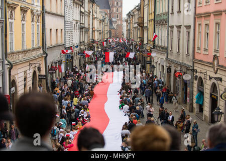 Krakau, Polen. Zum 2. Mai, 2018. Die Menschen halten eine polnische Flagge entlang der Royal Road während der nationalen Flagge Tag am Hauptplatz in Krakau. Stadt Pfadfinder, die heute versuchen, den nationalen Rekord entlang der Länge der nationalen Flagge zu brechen. Eine polnische Flagge mit 3 Meter Breite und mehr als zwei Kilometer lange Alle die königliche Straße besetzen, vom Florian Tor zu den Wawel-hügel. Credit: Omar Marques/SOPA Images/ZUMA Draht/Alamy leben Nachrichten Stockfoto