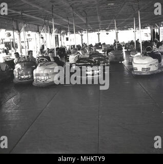 1960, historische, Leute an der Battersea Kirmes genießen Sie reiten die Dodgems oder Autoscooter, Battersea Park, London, England, UK. Die Kirmes war im Park als Teil des Festivals 1951 von Großbritannien feiern erbaut und war eine große Attraktion für junge Leute und Familien, die in diesem Zeitalter. Die dodgem Fahrt war im Besitz der Botton Bros betrieben - ihr Name ist auf den Autos - Albert und Jim Knopf, der in einem fairen Reisen um London und Südengland wuchs. Stockfoto