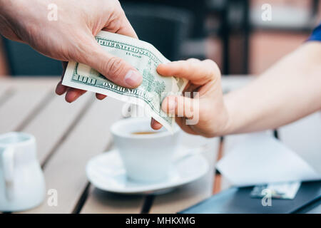 Zugeschnittenes Bild von Hand die bar bezahlen Mittagessen oder Kaffee, mit einem verschwommenen Hintergrund Stockfoto