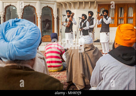 Musiker und Geschichtenerzähler mit traditionellen Punjabi Instrumenten und Zuschauer, bei Goldener Tempel, Amritsar, Punjab, Indien Stockfoto