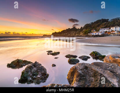 Pink und Gelb Himmel über Rock Pools am Strand, Steephill Cove. Stockfoto