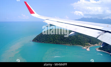 LANGKAWI, MALAYSIA - APR 4 2015: Blick aus dem Flugzeug Fenster mit Flügel eines Flugzeugs Landung auf einer tropischen Insel. Stockfoto