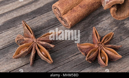 Sternanis und Zimt Sticks mit unverwechselbaren Geschmack und Duft. Nahaufnahme von Dekorative duftende Weihnachten Gewürze. Harmonische braun Holz- Hintergrund. Stockfoto