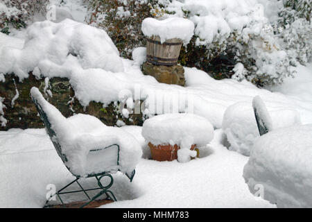 Eine Terrasse Winter Wonderland, mit Möbeln, Pflanzer, Töpfe und Garten Vegetation stark durch tiefen Schnee im Winter Stockfoto