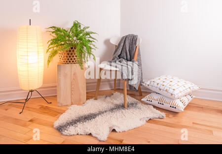 Zimmer mit gemütlichem Licht im skandinavischen Stil dekoriert, mit natürlichen Materialien. Stockfoto