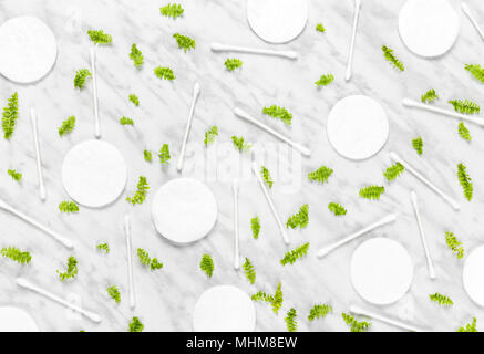 Wattepads, Q-Tips und grüne Blätter auf Marmor Hintergrund. Flach Komposition. Stockfoto