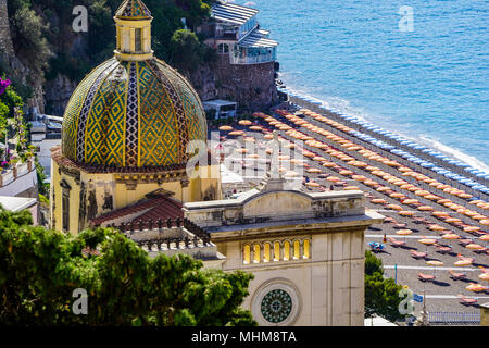 Nahaufnahme von Chiesa di Santa Maria Assunta in Positano, Amalfi Küste, Italien von oben mit Sonnenschirmen im Hintergrund Stockfoto