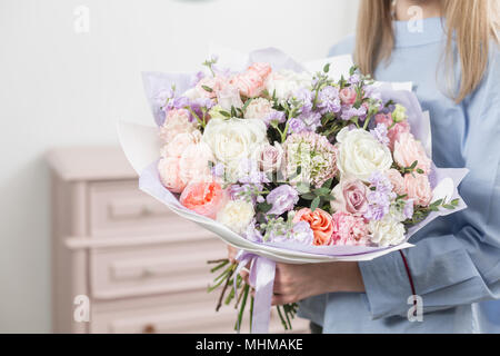 Sonnigen Frühlingsmorgen. Junge Frau mit einem schönen Luxus Blumenstrauß aus gemischten Blumen. Die Arbeit der Florist in einem Blumenladen Stockfoto