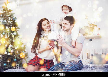 Glückliche Familie an Weihnachten Morgen Eröffnung gaben zusammen in der Nähe der Tanne. Das Konzept der Familie Glück und Wohlergehen Stockfoto