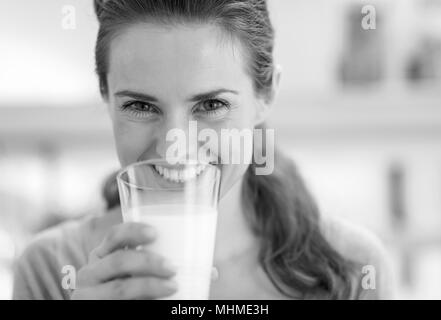 Lächelnde junge Frau Trinkmilch Stockfoto