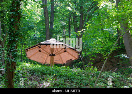 Holz- Sitzbank mit Tisch in der Natur unter Dach aus Holz macht einen guten Rastplatz im Wald Stockfoto