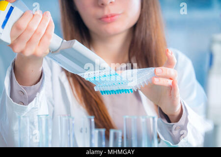 Student Frau mit multi Pipette und andere PCR-Produkte in der mikrobiologischen/genetischen Labor Stockfoto