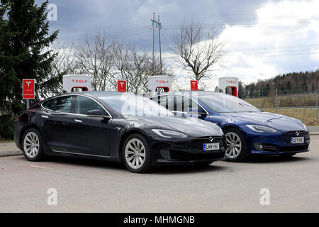 Zwei Tesla Model S Elektroautos der aktualisiert oder Facelift Exterior design laden die Batterie am Kompressor Station auf einem Tag der Frühling in Paimio, Stockfoto