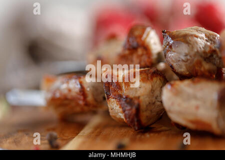 Shish Kebab aus Schweinefleisch Nahaufnahme. Saftiges Fleisch über dem offenen Feuer gekocht. Rustikal. Still-life auf einem hölzernen Hintergrund. Stockfoto