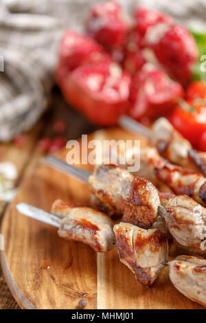 Shish Kebab aus Schweinefleisch Nahaufnahme. Saftiges Fleisch gekocht auf offenem Feuer und reifer Granatapfel. Rustikal. Still-life auf einem hölzernen Hintergrund. Stockfoto