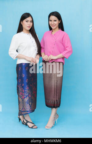 Portrait schöne asiatische Mädchen in traditionellen thailändischen Kleid am blauen Himmel Hintergrund isoliert. Baumwolle Kleid Stockfoto