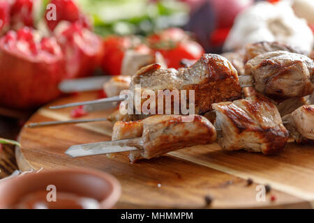 Lecker und saftig Kebabs aus Schweinefleisch. Stillleben mit Textilien auf einer hölzernen Hintergrund. Rustikal. Stockfoto