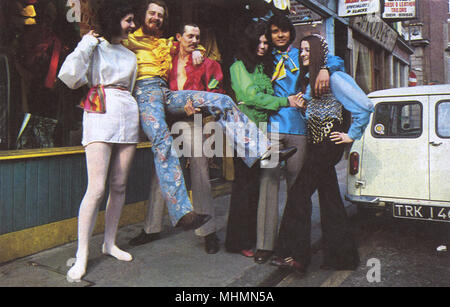 Eine Gruppe von Groovy Menschen tragen extravagante Mode der 60er Jahre in der Carnaby Street, London. Datum: 1966 Stockfoto