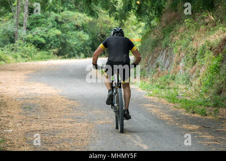 Mountainbiker auf einem Fahrrad hinauf zu einem Hügel Stockfoto