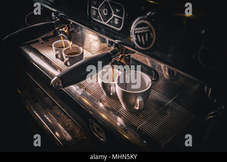 Professionelle Espressomaschine gießen frischen Kaffee in eine Tasse Stockfoto