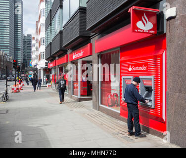 Ein Mann Geld abheben von der Santander Zweig der Tottenham Court Road, Bloomsbury, London, W1, Stockfoto