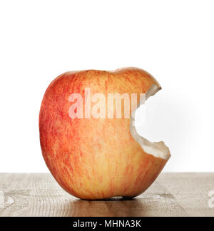 Gebissen Apple auf einem Holztisch und weißem Hintergrund Stockfoto