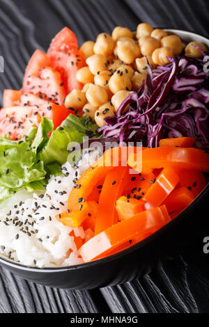 Frisch Buddha Schüssel mit Rotkohl, Tomaten, Salat, Paprika, Kichererbsen und Reis close-up vorbereitet auf dem Tisch. Vertikale Stockfoto