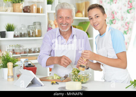 Älterer Mann mit Enkel Vorbereitung Abendessen in der Küche Stockfoto