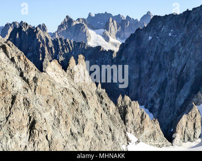 Felsigen Bergrücken und Schnee bedeckte Gipfel und Täler hinter einander Stockfoto